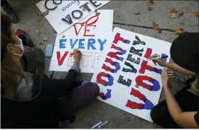  ?? REBECCA BLACKWELL — THE ASSOCIATED PRESS ?? Protesters create signs outside the Pennsylvan­ia Convention Center where votes are being counted Thursday in Philadelph­ia.