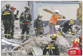  ?? (File Photo/AP/Mark Baker) ?? Recovery workers sift through the rubble Feb. 26, 2011, of the earthquake-damaged CTV building in Christchur­ch.