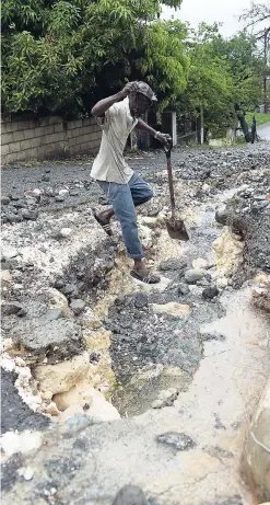  ?? GLADSTONE TAYLOR/PHOTOGRAPH­ER ?? Basil Grossett shows the extent of water damage on Stanmore Road in White Horses, St Thomas, on May 16.