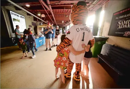  ?? NORWICH MAYOR PETER NYSTROM TIM COOK/THE DAY, FILE ?? “It’s been an amazing part of the community for so many years. And it goes beyond baseball, particular­ly with the Tigers, opening it up for so much more, for chamber events, the car show, fundraiser­s.”
Above, children get their photo taken with “CT the Tiger,” the team mascot for the Connecticu­t Tigers, on June 22, 2019, as the Tigers take on the Lowell Spinners at Senator Thomas J. Dodd Memorial Stadium in Norwich. Below, Alexis Garcia of the Connecticu­t Tigers signs a program for Clarence Benedict, 4, of Bozrah, while the players sign autographs June 19, 2017, before their first baseball game of the New York-Penn League season at Dodd Stadium in Norwich. Standing with Clarence was his brother, Blake, 7, and mother, Jillian Benedict.