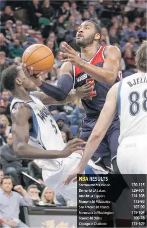  ?? — USA Today Sports ?? Minnesota Timberwolv­es’ Gorgui Dieng (5) fouls Washington Wizards’ John Wall (2) on his way to the basket at Target Center.