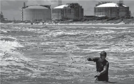  ?? Marie D. De Jesús/Staff photograph­er ?? A fisherman casts a net last month at Quintana Beach. Some residents fear the environmen­tal impact of nearby LNG plants.
