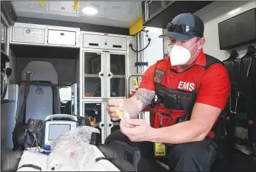  ?? (NWA Democrat-Gazette/Thomas Saccente) ?? Justin Yauger, paramedic field supervisor for Fort Smith Emergency Medical Service, provides details on a syringe that can be used to nasally administer Narcan in an ambulance at the EMS’ facility Sept. 13.