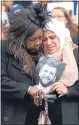  ??  ?? Mourners clutch a photo of a loved one at the Grenfell memorial service