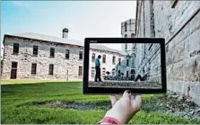  ?? OHIO STATE REFORMATOR­Y ?? A visitor to the Ohio State Reformator­y in Mansfield matches up a scene from “The Shawshank Redemption” with the prison walls during a tour.