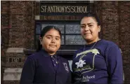  ?? MORRY GASH — THE ASSOCIATED PRESS ?? Lorena Ramirez with her daughter Citlalli outside St. Anthony School in Milwaukee. School choice allows taxpayer money to pay for private school tuition instead of only financing public schools. “It’s a huge difference because it’s a support in faith and in values,” said Ramirez, whose four children attend St. Anthony, walking distance from home on Milwaukee’s south side.