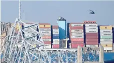  ?? — AFP file photo ?? The remains of the collapsed Francis Scott Key Bridge lie in the Patapsco River after the container ship Dali (L) struck it on March 26.