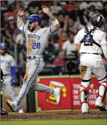  ?? DAVID J. PHILLIP/ASSOCIATED PRESS ?? Royals outfielder Kyle Isbel (left) scores on a wild pitch by Astros starter J.P. France during Saturday’s game in Houston. Kansas City won 3-2 and went on to complete a three-game sweep of the defending World Series champions.