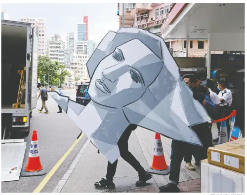  ?? TYRONE SIU / REUTERS ?? Police in Hong Kong collect a cut out of the Goddess of Democracy on Thursday at the June 4th Museum, which commemorat­es the 1989 Tiananmen Square crackdown, as they search the museum after arresting four members of the Hong Kong Alliance in Support of Patriotic Democratic Movements in China.