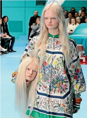  ?? AP ?? A model carries a fake head on the runway for Gucci. Gucci sales have spiked in the US.