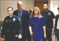  ?? The Associated Press ?? MURDER TRIAL: Former Dallas police officer Amber Guyger, center, arrives for the first day of her murder trial in the 204th District Court at the Frank Crowley Courts Building in Dallas, Monday.