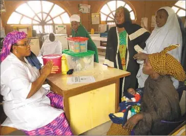  ?? Photograph­s by Krista Mahr For The Times ?? NUTRITIONI­ST Salamatu Jibril, left, speaks to a woman who runs an orphanage in Kaduna, Nigeria.