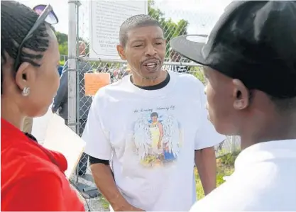  ?? KIM HAIRSTON/BALTIMORE SUN PHOTOS ?? From left, Taneisha Hicks of West Baltimore listens as Muggsy Bogues speaks with her son, Tyler Jackson, 17. Jackson wanted to meet Bogues, whom he has admired for years. Bogues and the Baltimore City Recreation and Parks hosted the second Sherron...