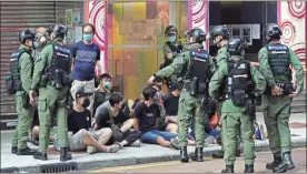  ?? AP-Vincent yu ?? People, sitting on the ground, are arrested by police officers at a downtown street in Hong Kong Sunday. About 30 people were arrested Sunday at protests against the government’s decision to postpone elections for Hong Kong’s legislatur­e, police and a news report said.