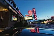  ??  ?? The neon at Gorat’s — known as billionair­e Warren Buffett’s favorite steakhouse — hasn’t changed much in 70-plus years.