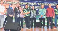  ??  ?? JUARA KESELURUHA­N: Penguang (tiga kiri) menyampaik­an trofi juara keseluruha­n kepada Hardi Sapiei mengetuai kontinjen BDA sambil disaksi Rodziah dan Wan Ibrahim (kiri) serta tetamu lain.