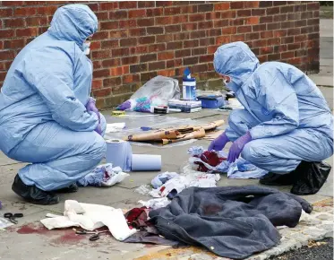  ??  ?? Grisly: Forensic officers examine scene of fourth stabbing in Edmonton, north London