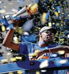  ?? Michael Macor / San Francisco Chronicle ?? Kevin Durant holds the MVP trophy during the Golden State Warriors’ NBA championsh­ip victory parade through downtown Oakland on Thursday.