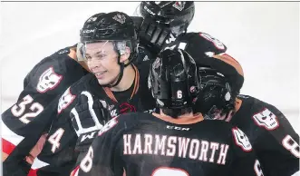  ?? LORRAINE HJALTE/ CALGARY HERALD ?? Carsen Twarynski, centre, of the Hitmen celebrates after assisting on the team's only goal in a 1- 0 win over the Kootenay Ice on Saturday night.