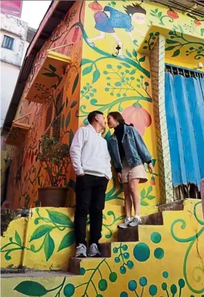  ?? — Viet Nam News/aNN ?? Now kiss: a couple posing in front of a colour mural in dalat.