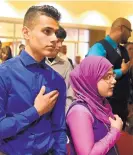  ?? DEAN HANSON/JOURNAL ?? Brother and sister Yousif, left, and Ghadeer Mustafa, whose family comes from Iraq, say the Pledge of Allegiance during a citizenshi­p ceremony Friday in Rio Rancho.