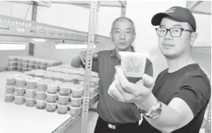  ??  ?? JUNZ menunjukka­n benih nanas MD2 semasa melawat makmal kultur tisu nanas Arus Primajaya di Benut, Johor. Turut kelihatan Ketua Pegawai Eksekutif Arus Primajaya, Tan (belakang).