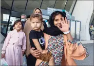  ?? Gemunu Amarasingh­e / Associated Press ?? A girl evacuated from Kabul, Afghanista­n, waves as she walks to a bus at Washington Dulles Internatio­nal Airport on Saturday.