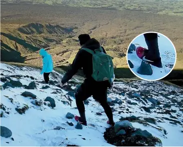  ?? LINDSAY MAINDONALD ?? Two people are photograph­ed descending from Fanthams Peak, Taranaki Maunga, in icy conditions wearing street shoes and light clothing, not far from where two climbers had died a week before. Inset, a close-up of the man’s footwear.