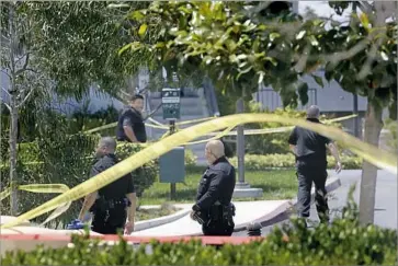  ?? Photograph­s by Jay L. Clendenin Los Angeles Times ?? POLICE stand near the site of a gunfight between officers and Qasim Knox on June 29 in El Segundo. Knox was wounded, as was a SWAT officer who was shot by the suspect, police say. Knox faces a total of 19 charges.