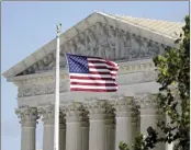  ?? AP file photo ?? An American flag blows in the wind in front of the Supreme Court building on Capitol Hill in Washington, Nov. 2,
2020.