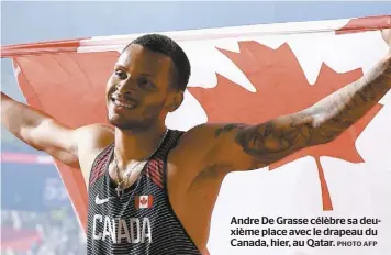  ?? PHOTO AFP ?? Andre De Grasse célèbre sa deuxième place avec le drapeau du Canada, hier, au Qatar.