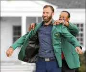  ?? CURTIS COMPTON/AJC 2020 ?? 2019 Masters champion Tiger Woods presents Dustin Johnson his first green jacket after winning the 2020 Masters on Nov. 15 in Augusta.