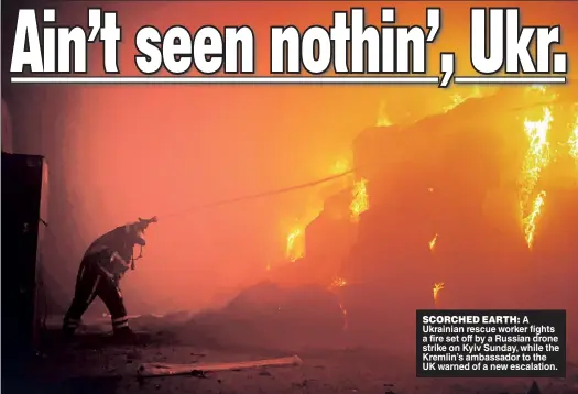  ?? ?? SCORCHED EARTH: A Ukrainian rescue worker fights a fire set off by a Russian drone strike on Kyiv Sunday, while the Kremlin’s ambassador to the UK warned of a new escalation.