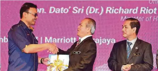  ?? PIC BY ZULFADHLI ZULKILFI ?? UKM (Research and Innovation Affairs) deputy vice-chancellor Professor Dr Mohd Ikhwan Toriman (left) presenting a token of appreciati­on to Mohd Gazali Abas (second from right) at the launch of the NC4IR-TVET recently. Looking on is Human Resources...