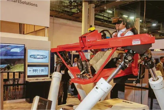  ?? Gary Fountain ?? Yao Zaiku tries out a rally car simulator that Bosch Rexroth was using at the Offshore Technology Conference to demonstrat­e electric drive and control technology.