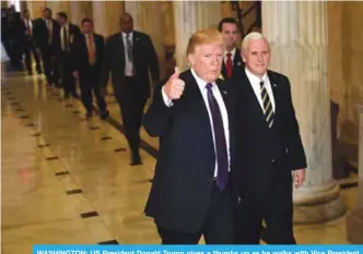  ??  ?? WASHINGTON: US President Donald Trump gives a thumbs up as he walks with Vice President Mike Pence as he departs Capitol Hill in Washington. —AP photos