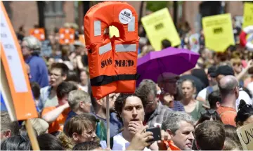  ??  ?? A protester holds up a life jacket during a demonstrat­ion to denounce the closure of Mediterran­ean ports to migrant rescue boats in Berlin. — AFP photo