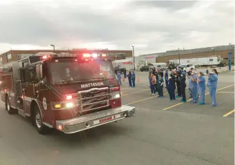  ?? TED SLOWIK/DAILY SOUTHTOWN ?? A Matteson fire engine rolls past a group of health care workers during a parade as the community shows support for hospital employees April 22, 2020, at Franciscan Health Olympia Fields.