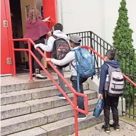  ??  ?? Una profesora conduce a sus estudiante­s hacia el interior de una escuela primaria de Brooklyn