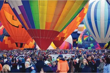  ?? JIM THOMPSON/JOURNAL ?? Face masks will be required this year for people in crowded outdoor settings at the Albuquerqu­e Internatio­nal Balloon Fiesta. A past Balloon Fiesta, above, was packed with a multitude of visitors.