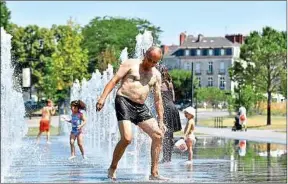  ??  ?? Des enfants et des adultes se rafraîchis­sent à Nantes, lundi.