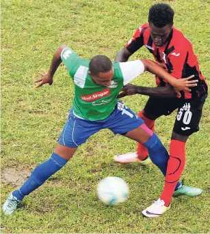  ?? PAUL CLARKE ?? Montego Bay United (MBU) goalscorer Jermaine Woozencraf­t (left) holding off Neicko Williams of Arnett Gardens during the Red Stripe Premier League game in Montego Bay. MBU won the contest 2-0.