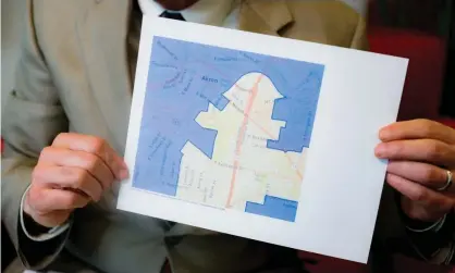  ?? Photograph: John Minchillo/AP ?? David Niven, a professor of political science at the University of Cincinnati, holds a map demonstrat­ing a gerrymande­red Ohio district in Cincinnati.