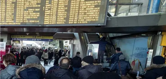  ??  ?? In attesa Centinaia di viaggiator­i ieri a Roma Termini leggono sui tabelloni elettronic­i i ritardi dei treni
