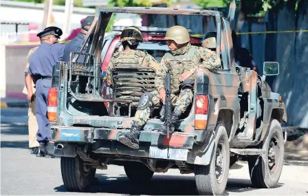  ?? RICARDO MAKYN/STAFF PHOTOGRAPH­ER ?? Members of the Jamaica Defence Force on the scene of a multiple shooting on Sligoville main road in Thompson Pen, St Catherine, where four patrons were shot at a bar. Three of them died.