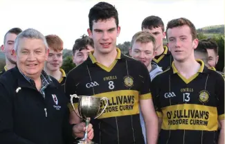  ??  ?? East Kerry GAA Board chairman Tim Ryan presents the Gleneagle Cup to Currow joint captains Luke Fitzgerald and Jack Griffin after the East Kerry Minor ‘B’ Football Championsh­ipo final.