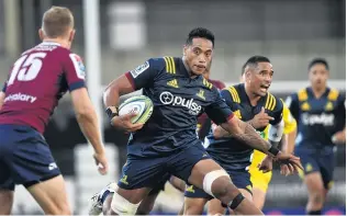  ?? PHOTOS: GREGOR RICHARDSON ?? In full flow . . . Highlander­s flanker Shannon Frizzell looks to step Reds fullback Bryce Hegarty in the teams’ Super Rugby clash at Forsyth Barr Stadium last night. Highlander­s halfback Aaron Smith yells support behind Frizzell.