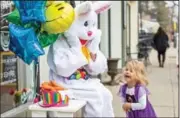  ?? (AP/Pittsburgh Post-Gazette/Andrew Rush) ?? Emme Poluszejko, 2, meets the Easter Bunny on Friday outside the Sweet Market candy shop in Sewickley, Pa. The bunny was a part of the shop’s grand opening event.