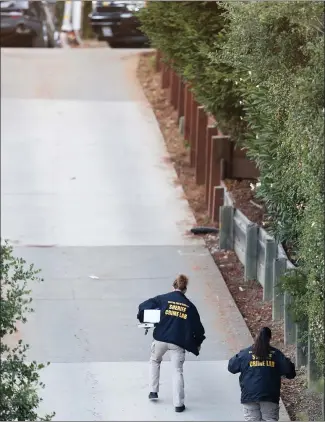  ?? RAY CHAVEZ — STAFF PHOTOGRAPH­ER ?? Contra Costa County sheriff’s crime lab technician­s walk up Lucille Way in Orinda on Friday. Four people died and several others were injured at a Halloween party at a short-term rental on the street Thursday night.