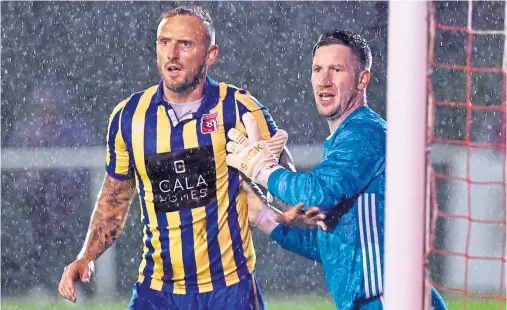  ?? Photograph by Scott Baxter ?? AMBITION: Jonny Smith, in Inverurie Locos colours, jostling with Formartine United goalkeeper Kevin Main.